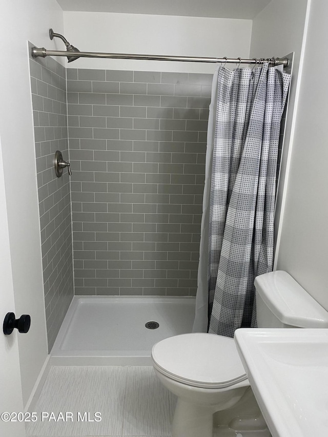 full bath with tile patterned floors, a stall shower, and toilet