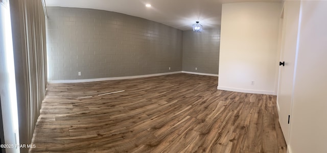 spare room with baseboards and dark wood finished floors