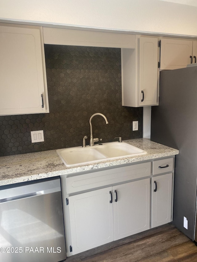 kitchen with dark wood-style floors, appliances with stainless steel finishes, decorative backsplash, and a sink