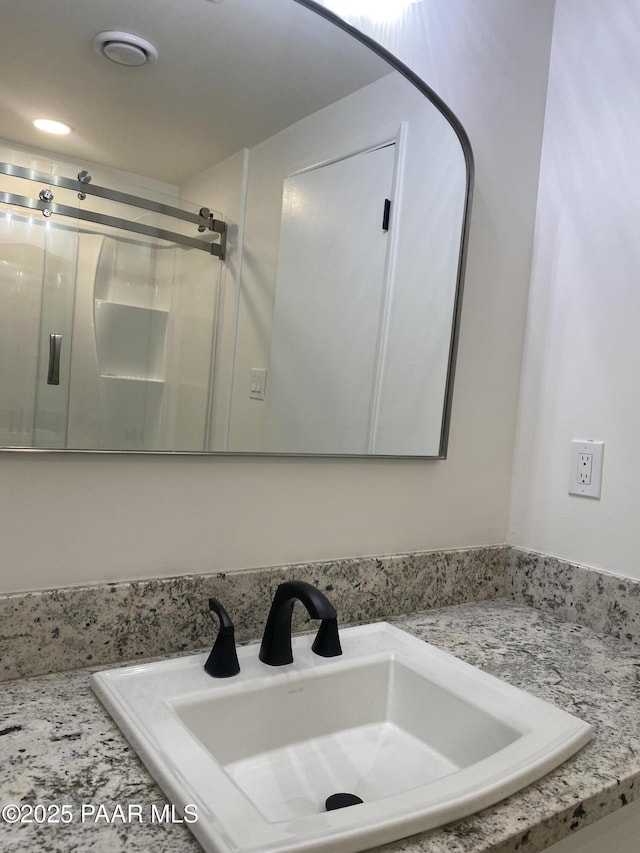 bathroom featuring a sink and a stall shower
