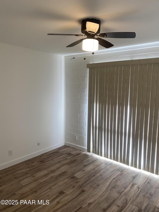unfurnished room with baseboards, a ceiling fan, and wood finished floors