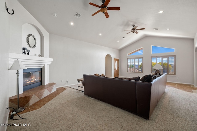 living room with ceiling fan, light colored carpet, and vaulted ceiling