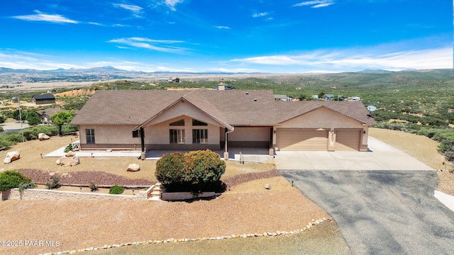 single story home with a mountain view and a garage