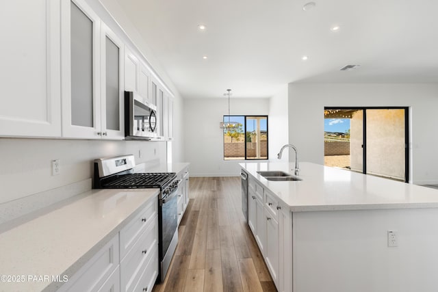 kitchen featuring white cabinetry, appliances with stainless steel finishes, a sink, and visible vents