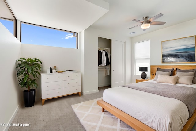 bedroom with multiple windows, light carpet, a closet, and visible vents