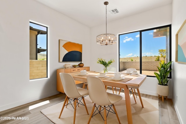 dining area with visible vents, light wood-style floors, and a wealth of natural light