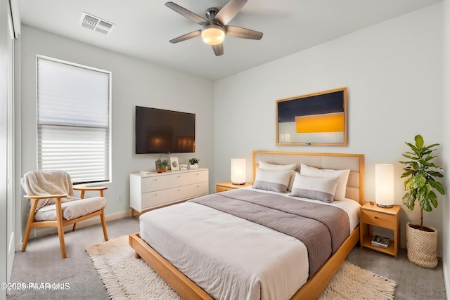bedroom featuring baseboards, visible vents, a ceiling fan, and light colored carpet