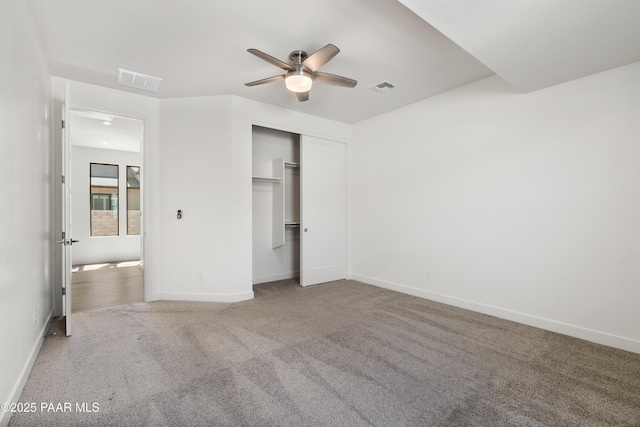 unfurnished bedroom with carpet floors, baseboards, visible vents, and a closet