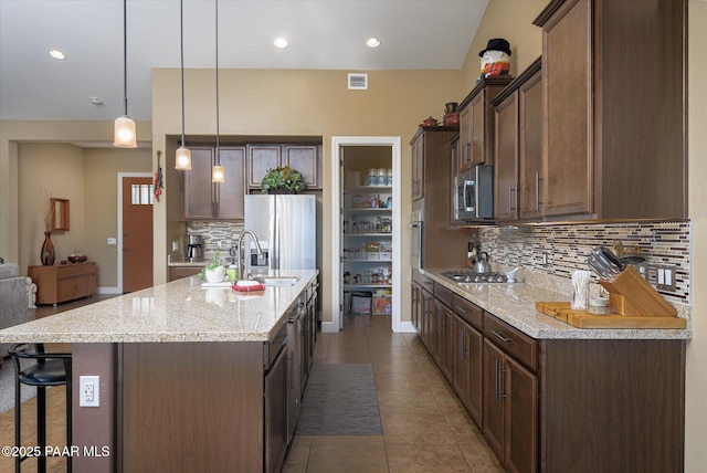 5245 Wellness Way, Prescott, AZ 86301 - kitchen with stainless steel appliances, a kitchen bar, a sink, decorative backsplash, and an island with sink