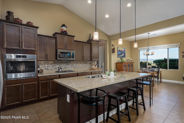5245 Wellness Way, Prescott, AZ 86301 - kitchen featuring stainless steel appliances, dark tile patterned floors, tasteful backsplash, a breakfast bar area, and a sink
