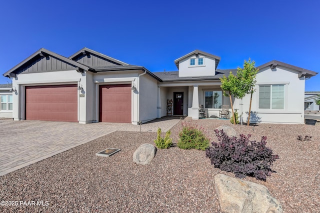 7028 Corral Ct, Prescott, AZ 86305 - view of front of property featuring covered porch, decorative driveway, an attached garage, and board and batten siding