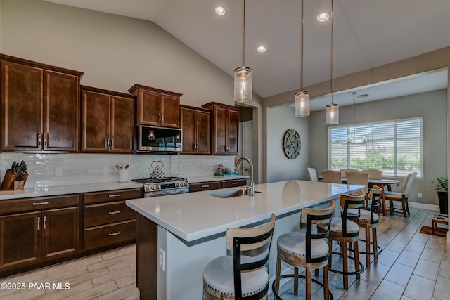 7028 Corral Ct, Prescott, AZ 86305 - kitchen with appliances with stainless steel finishes, lofted ceiling, backsplash, a breakfast bar area, and light countertops