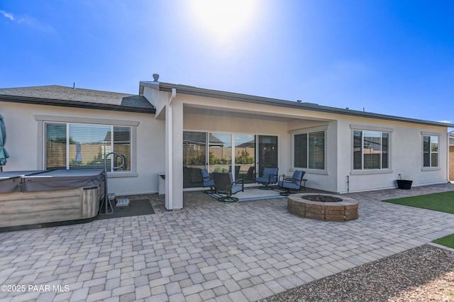 7028 Corral Ct, Prescott, AZ 86305 - rear view of property featuring a hot tub, a patio area, an outdoor fire pit, and stucco siding