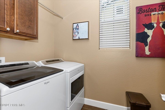 clothes washing area with washer and clothes dryer and cabinets