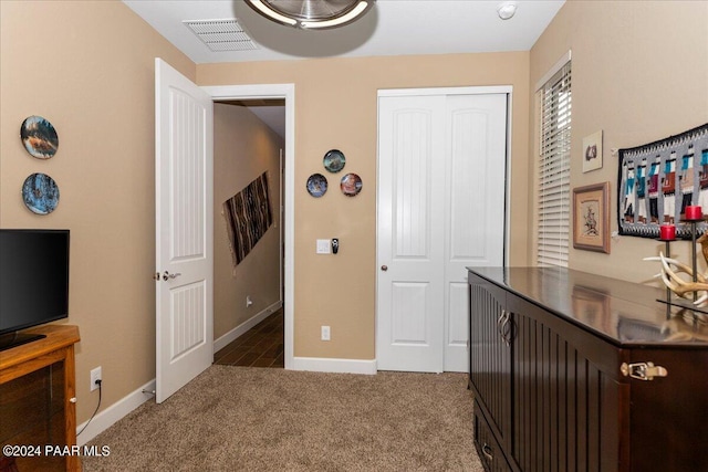 hall with dark colored carpet