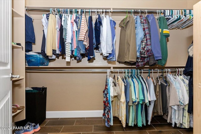 spacious closet with dark tile patterned floors