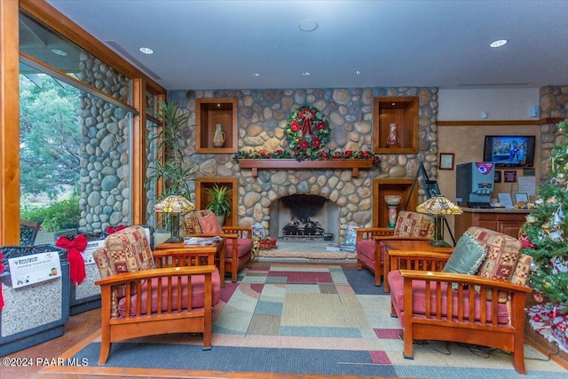 living room featuring carpet and a stone fireplace