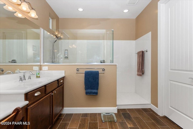 bathroom with a tile shower and vanity