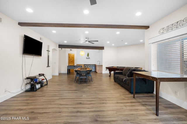 living room featuring beam ceiling, wood-type flooring, and ceiling fan