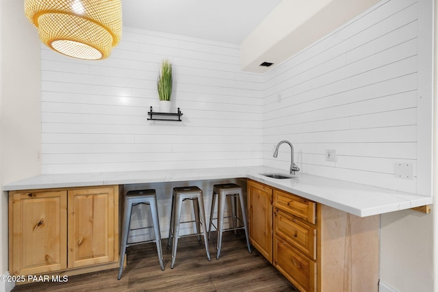 kitchen with dark wood-type flooring, a kitchen breakfast bar, and sink