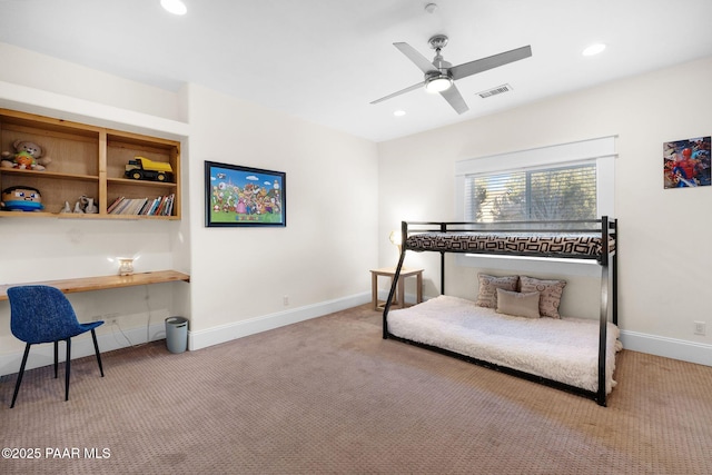 carpeted bedroom featuring ceiling fan and built in desk