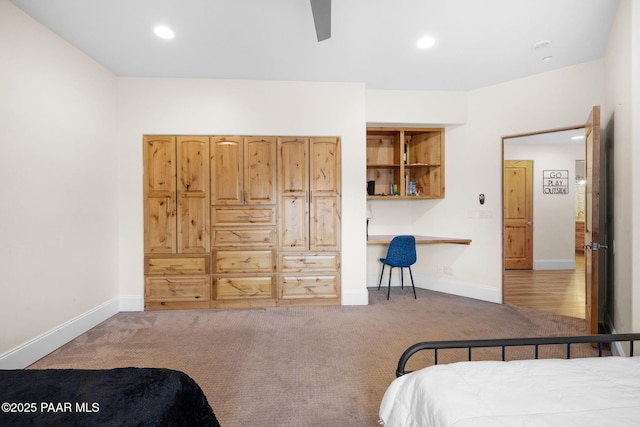 bedroom featuring ceiling fan, built in desk, and carpet floors