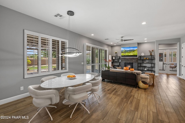 dining area with a ceiling fan, wood finished floors, a glass covered fireplace, baseboards, and recessed lighting