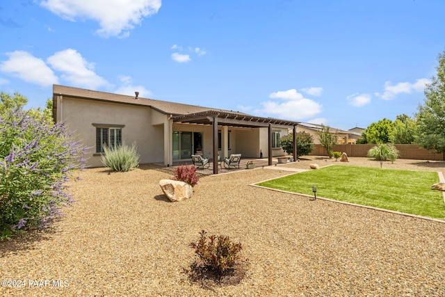 back of property featuring fence, a pergola, stucco siding, a yard, and a patio area