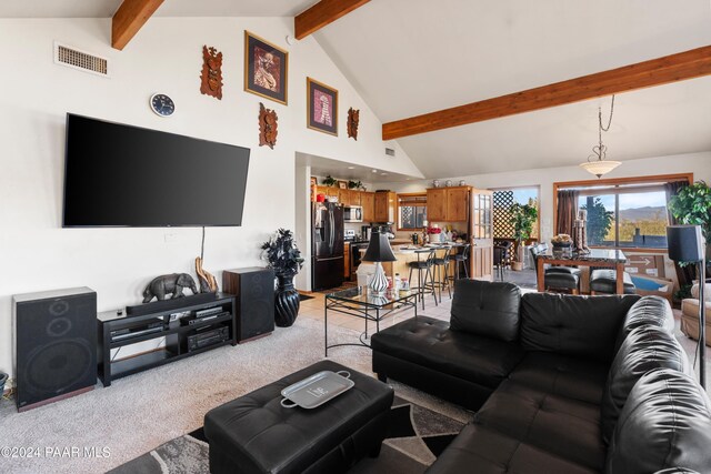 carpeted living room featuring beam ceiling and high vaulted ceiling