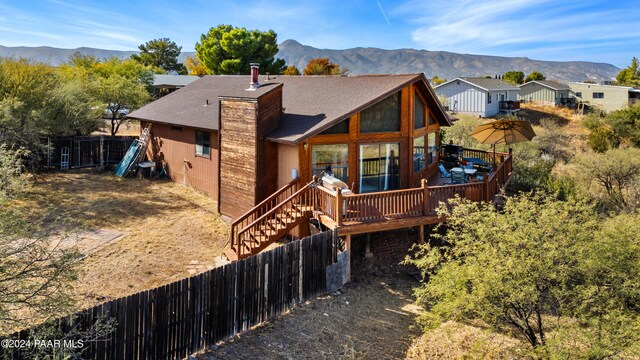 back of property featuring a deck with mountain view