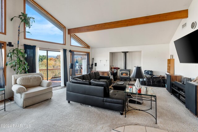 carpeted living room featuring beamed ceiling, a wood stove, and high vaulted ceiling