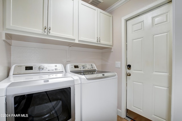 laundry area with cabinets, crown molding, and washing machine and clothes dryer