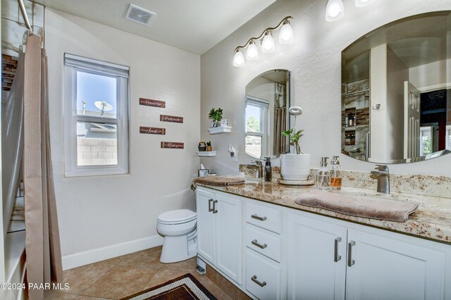 bathroom with tile patterned flooring, vanity, and toilet