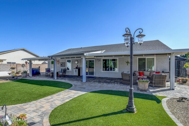 back of house featuring outdoor lounge area, a patio area, and a yard