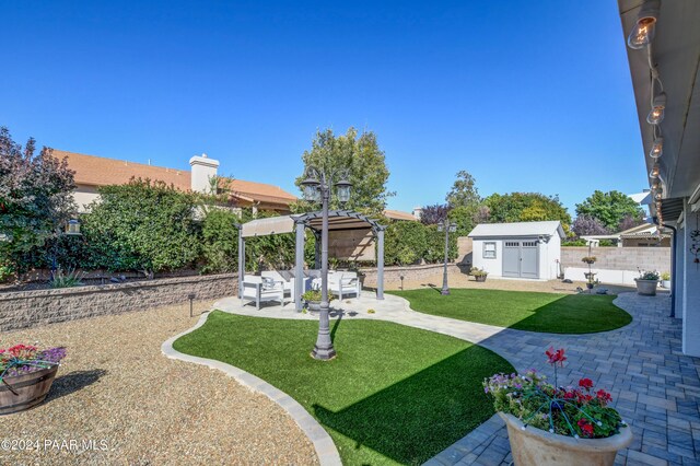 view of yard with outdoor lounge area, a storage unit, and a patio area