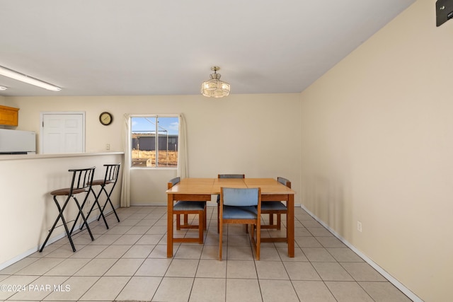 dining room with an inviting chandelier and light tile patterned flooring