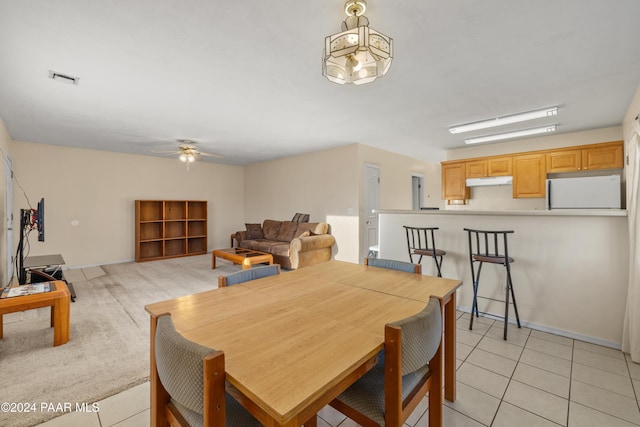 tiled dining space with ceiling fan