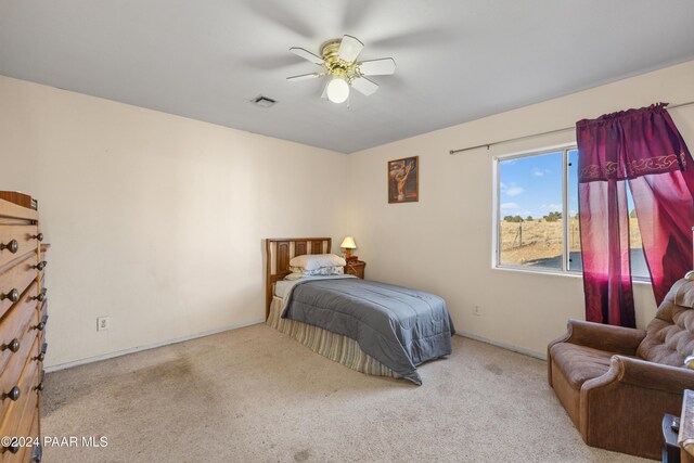 carpeted bedroom with ceiling fan and ensuite bath