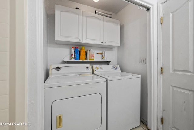 laundry area with washing machine and clothes dryer and cabinets