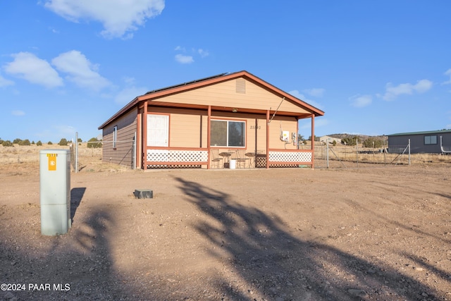 view of front of property featuring a porch and fence