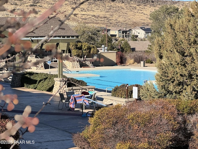 pool with a patio area and fence