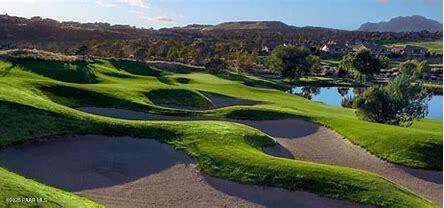 view of property's community with golf course view and a water and mountain view