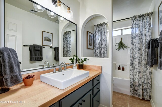 bathroom with shower / bath combination with curtain, visible vents, vanity, and tile patterned floors