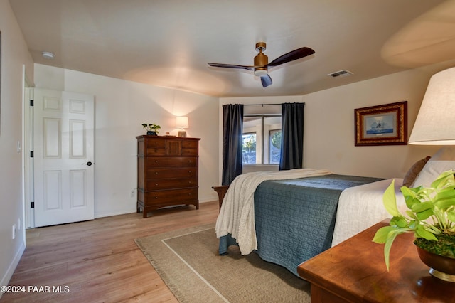 bedroom with light wood-type flooring, baseboards, visible vents, and a ceiling fan