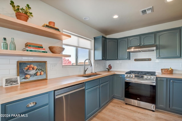 kitchen with visible vents, stainless steel appliances, under cabinet range hood, open shelves, and a sink