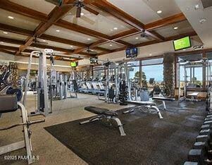 gym featuring coffered ceiling and a ceiling fan