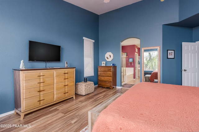 2315 W Desert Willow Dr, Cottonwood, AZ 86326 - bedroom featuring arched walkways, a high ceiling, baseboards, and light wood-style flooring