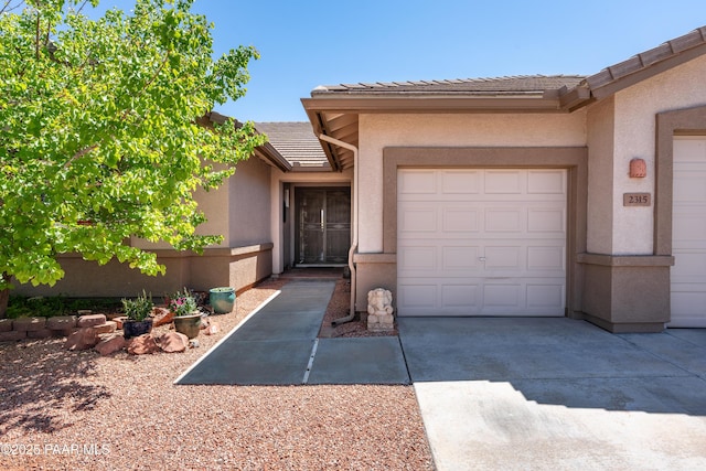 2315 W Desert Willow Dr, Cottonwood, AZ 86326 - view of front of house featuring concrete driveway, a garage, a tile roof, and stucco siding