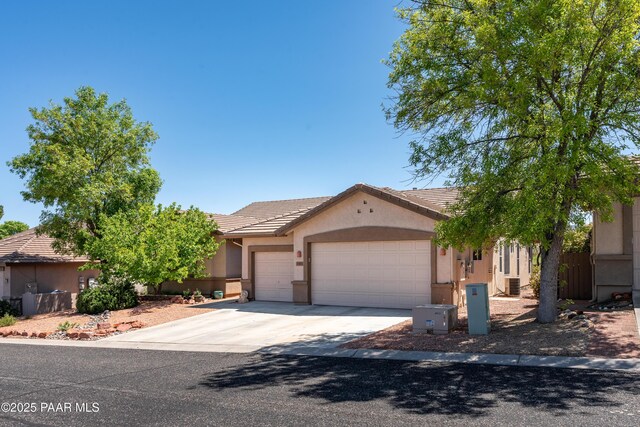 2315 W Desert Willow Dr, Cottonwood, AZ 86326 - view of front of home with a tile roof, a garage, fence, concrete driveway, and stucco siding