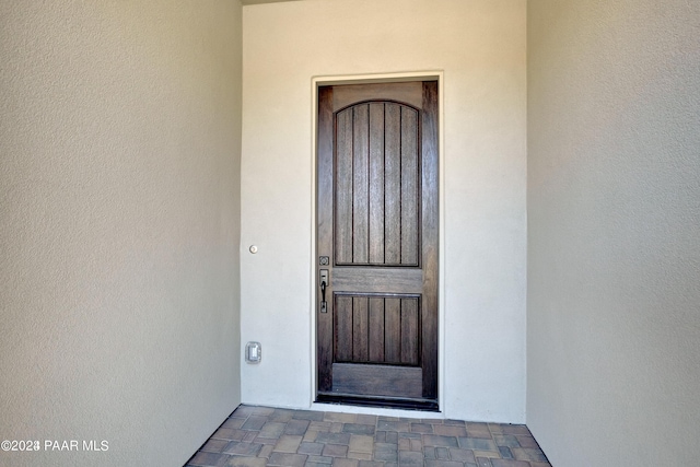 entrance to property featuring stucco siding
